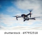 Drone flying overhead in cloudy blue sky