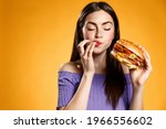 Woman eating cheeseburger with...