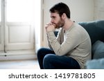 Unhappy depressed caucasian male sitting and lying in living room couch feeling desperate a lonely suffering from depression. In stressed from work, anxiety, heartbroken and men Health care concept.