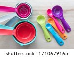 Set of colorful measuring cups and measuring spoons use in cooking lay on wood tabletop in top view.