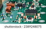 Small photo of Closeup of surface mounted electronic components in radio-frequency circuits of TV tuner. Semiconductor microchip and air core coils with various small inductors, capacitors or resistors on green PCB.