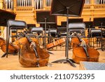 Small photo of Moscow, Russia-December, 26, 2021: Cellos, bows, music stands in the intermission of a classical music concert. Focus on the left cello string stand.