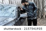 Small photo of Male burglar robber passing by lookes through crack in window of parked empty auto, he opens unlocked door, tooks cash money or smartphone or wallet, and fleds scene with stolen item.