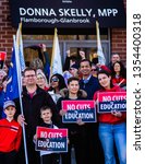 Small photo of Hamilton, Ontario, Canada - March 29, 2019: Teachers, EAs, Parents, Children and other Union members march in front of MPP Donna Skelly's office to protest Ford's plan to cut the education budget.