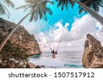 Beautiful girl on swing coconut palms on beach at Daimond  beach, Nusa Penida island Bali ,Indonesia