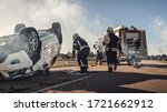 Small photo of Rescue Team of Firefighters Arrive on the Car Crash Traffic Accident Scene on their Fire Engine. Firemen Grab their Tools, Equipment and Gear from Fire Truck, Rush to Help Injured, Trapped People