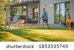 Small photo of Smiling Beautiful Family of Four Play Fetch flying disc with Happy Golden Retriever Dog on the Backyard Lawn. Idyllic Family Has Fun with Loyal Pedigree Dog Outdoors in Summer House Backyard