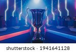 Two Esport Teams of Pro Gamers Play to Compete in Video Game on a Championship. Stylish Neon Cyber Games Online Streaming Tournament Arena with Trophy in the Center.