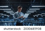 Small photo of Portrait of IT Specialist Uses Laptop in Data Center. Server Farm Cloud Computing Facility with Male Maintenance Administrator Working. Cyber Security and Network Protection.