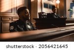 Small photo of Court of Law and Justice Trial Stand: Portrait of Black Policeman Witness Giving Testimony to Judge, Jury. African American Officer Providing Evidence. Law Enforcement Agent in Courthouse.