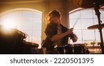 Small photo of Portrait of a Young Female Playing Drums During a Band Rehearsal in a Loft Studio with Warm Sunlight at Daytime. Drummer Girl Practising Before a Live Concert on Stage in Local Venue.