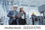 Small photo of Two Professional Heavy Industry Engineers Wearing Hard Hats at Factory. Walking and Discussing Industrial Machine Facility, Working on Laptop. African American Manager and Technician at Work.
