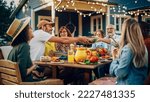 Small photo of Big Family Vegetarian Party Gathered Together at a Table with Relatives and Friends. Young and Senior People are Eating Vegan Food, Drinking, Passing Dishes, Joking and Having Fun.