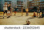 Small photo of Portrait of a Young Handsome Boy Making a Penalty Kick During a Friendly Neighborhood Soccer Match with Local Kids. Talented Football Player Practicing Free Kicks in the Backyard.