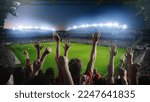 Small photo of Establishing Shot of Fans Cheer for Their Team on a Stadium During Soccer Championship Match. Teams Play, Crowds of Fans Scream and Celebrate Victory, Goal. Football Cup Tournament