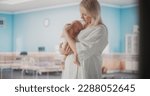 Small photo of Young Happy Mother Holding Her Newborn Child, Bonding with Little Infant in Modern Maternity Hospital. Blessed Caucasian Woman Soothing Her Baby. Medical Health Care, Maternity and Parenthood Concept