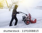 young man removes snow with a snowplower