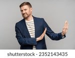 Small photo of Frustrated man with disgust on serious face incredulously pushes away troubles with gesture of hands isolated on gray background. Male with angry expression refuse something bad showing denial.