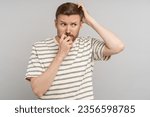 Small photo of Nervous guy with mental health disorder in difficult thought scratches back of head, bites nails, looking away, isolated background. Worried man with shame signs of an unstable psyche afraid exposure.