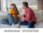 Small photo of Displeased woman manipulator ignoring husband wanting to talk. Frustrated wife abuser creates toxic atmosphere in family couple. Domestic emotional stress, misunderstanding, relationship problems.