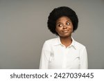 Thoughtful uncertain african american female with expression of doubt, hesitation on face. Confused pensive black female thinking of answer to hardball question isolated on grey studio background.
