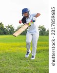 Small photo of Female Indian cricket player wearing protective gear and hitting the ball with a bat on the field