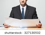 Businessman comparing two documents, neutral background