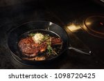 Cooking steak in a cast iron pan in a fine dining restaurant.