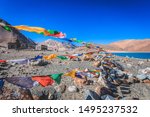 Small photo of Panoramic landscape of Pangong Tso lake and Himalayan mountains range viewed through colorful Tibetan prayer flags aflutter against rocky mountains of majestic Himalayas and blue sky in Ladakh, India.