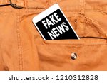 Small photo of Writing note showing Fake News Motivational Call. Business photos showcasing False Unsubstantiated Information Hoax Concept on cell phone on pant pocket
