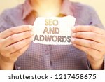 business woman holding tear paper with SEO AND ADWORDS text