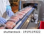 Small photo of Conveyor Belt Food.Factory for the production of food from meat.Production line with packaging .Food products meat chicken in plastic packaging on the conveyor.
