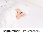 Small photo of Sleep, early morning, waking up, noisy neighbors interfere, lack of sleep, too lazy to get out of bed. Young caucasian woman sleeps covering her head with pillows.