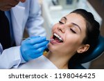 Small photo of Last touch up. Close-up of dentist examining his beautiful patient in dentist’s office