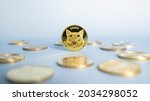 Small photo of Shiba Inu or Shib coin standing centrally placed among bunch of crypto coins on blue background. Close-up, soft focus. Banner with golden Shiba token.