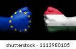 Flag of European Union and Hungary painted on two clenched fists facing each other on black background/Hungary in the EU concept