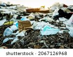 Small photo of Used face mask discard in household garbage. Medical waste disposal with unhygienic management. Contaminated waste in community. Disposable earloop face mask waste garbage on floor. Coronavirus impact
