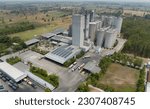 Small photo of Aerial view of animal feed factory. Agricultural silos, grain storage silos, and solar panel on roofs of industrial plants. Industrial landscape. Agriculture industry. Factory with sustainable energy.