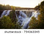 A September sunset casts a warm early autumn glow over the iconic Kakabeka Falls outside Thunder Bay, Ontario, Canada.