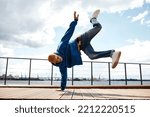 Small photo of Motion shot of young man doing breakdance stunts outdoors against sky, copy space