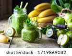 Two healthy green smoothies with spinach, banana, apple, kiwi and mint in glass jar and ingredients. Detox, diet, healthy, vegetarian food concept