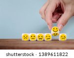 Hand Changing with smile emoticon icons  face on Wooden Cube,hand flipping unhappy turning to happy symbol