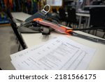Small photo of Harness inspection checklist paper placing on the table, defocused harness, shock absorber lanyards fall arrest fall protection safety assessment prior to work approval sign off of each task