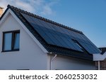 Newly build houses with solar panels attached on the roof against a sunny sky Close up of new building with black solar panels. Zonnepanelen, Zonne energie, Translation: Solar panel, Sun Energy