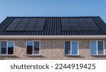 Small photo of Newly build houses with solar panels attached on the roof against a sunny sky, new buildings with black solar panels. Zonnepanelen, Zonne energie, Translation: Solar panel Sun Energy. Housing market