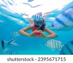 Asian woman on a snorkeling trip at Samaesan Thailand. dive underwater with Nemo fishes in the coral reef sea pool. Travel lifestyle, watersport adventure, swim activity on a summer beach holiday 