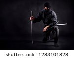 Small photo of Ninja samurai crouched on one leg and propped on a sword
