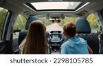 Small photo of Family idyll concept where lovely happy brother and sister sitting at the rear seat of the auto,watch the way they are driving on and tell stories to their mom who's behind the wheel