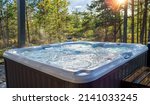 Small photo of A warm hot tub in a beautiful forest landscape at sunset. You can relax outdoors in nature while enjoying the warmth of the hot tub.