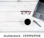 Laptop glasses coffee cup and two silver pen office workspace top view copy space